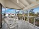 Inviting porch area with wicker seating and a view of nearby houses and lush green trees at 650 Penfield St, Longboat Key, FL 34228