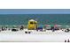 A sunny beach day with beachgoers enjoying the sand and surf with a lifeguard tower at 710 Birdsong Ln, Sarasota, FL 34242