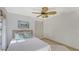 Bright bedroom featuring a decorative ceiling fan, light wood floors, and a closet for ample storage at 710 Birdsong Ln, Sarasota, FL 34242