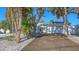 Single-story home with a well-kept lawn, mature trees, and a two-car garage at 710 Birdsong Ln, Sarasota, FL 34242