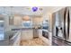 Bright white kitchen with stainless steel appliances, granite countertops, and wood look tile flooring at 710 Birdsong Ln, Sarasota, FL 34242