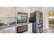 A clean white kitchen showcasing the oven, refrigerator and storage space at 710 Birdsong Ln, Sarasota, FL 34242