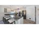 Bright kitchen with stainless steel appliances, granite countertops, breakfast bar and wood-look tile flooring at 710 Birdsong Ln, Sarasota, FL 34242