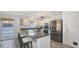 Bright kitchen with stainless steel appliances, granite countertops, breakfast bar and wood-look tile flooring at 710 Birdsong Ln, Sarasota, FL 34242