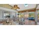 Sunroom featuring a vaulted ceiling, ceiling fan, comfortable seating, and access to outdoor deck at 710 Birdsong Ln, Sarasota, FL 34242
