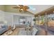 Bright sunroom features high ceilings, ceiling fan, comfortable seating, and access to outdoor deck at 710 Birdsong Ln, Sarasota, FL 34242