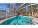 A private, in-ground pool is enclosed by a screened cage that protects from insects and debris at 710 Birdsong Ln, Sarasota, FL 34242