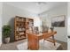 Bright home office with a wooden desk, bookcase, and a comfortable chair at 7632 Plantation Cir, Bradenton, FL 34201