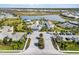 Expansive aerial view of the community clubhouse, pool, tennis courts, and surrounding landscape and water features at 8271 Redonda Loop, Bradenton, FL 34202