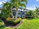 Landscaped backyard featuring lush greenery, palm trees, a screened-in pool, and spa for outdoor enjoyment at 8271 Redonda Loop, Bradenton, FL 34202