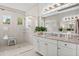 Modern bathroom with dual sinks, granite counters, glass shower, and sleek white cabinetry at 8271 Redonda Loop, Bradenton, FL 34202