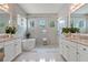 Bright bathroom featuring dual vanities with granite counters, a soaking tub, and a glass-enclosed shower at 8271 Redonda Loop, Lakewood Ranch, FL 34202