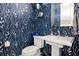 Stylish bathroom with a striking wallpaper design, a pedestal sink, and modern fixtures at 8271 Redonda Loop, Lakewood Ranch, FL 34202