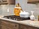 Modern kitchen featuring a sleek cooktop with stone countertops and stylish backsplash at 8271 Redonda Loop, Lakewood Ranch, FL 34202