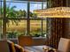 Dining room featuring a view of the water and trees from the window and an elegant chandelier hanging above table at 8271 Redonda Loop, Lakewood Ranch, FL 34202