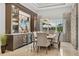 Elegant dining room with a modern light fixture, wine bar, and large windows at 8271 Redonda Loop, Lakewood Ranch, FL 34202