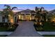 Stunning home exterior featuring a brick driveway, a two-car garage, and lush landscaping at 8271 Redonda Loop, Lakewood Ranch, FL 34202