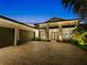 Attractive home featuring a brick paver driveway and tropical landscaping at 8271 Redonda Loop, Lakewood Ranch, FL 34202