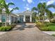Lovely home with a brick driveway, two-car garage, a well-manicured lawn, and vibrant landscaping at 8271 Redonda Loop, Lakewood Ranch, FL 34202