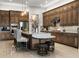 Open kitchen featuring a large island with seating, wooden cabinets, and stainless steel appliances at 8271 Redonda Loop, Lakewood Ranch, FL 34202