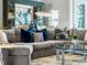 Comfortable living room featuring a gray sectional sofa with decorative pillows and modern decor at 8271 Redonda Loop, Lakewood Ranch, FL 34202
