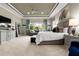 Spacious primary bedroom with a large bed, tray ceiling, sitting area and bright natural light at 8271 Redonda Loop, Lakewood Ranch, FL 34202