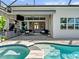 Outdoor kitchen area featuring built-in appliances, a retractable awning, and access to the luxurious pool area at 8271 Redonda Loop, Bradenton, FL 34202