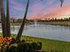 Scenic view of a community pond with fountain, palm trees, and a colorful sunset at 8271 Redonda Loop, Bradenton, FL 34202