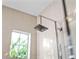 Modern shower featuring a square rainfall shower head and sleek chrome fixtures, complemented by tiled walls and a window at 8271 Redonda Loop, Lakewood Ranch, FL 34202