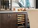Stylish wet bar area with wine fridge, glassware display, and elegant countertop at 8271 Redonda Loop, Lakewood Ranch, FL 34202