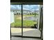View of a spacious backyard with a pond from sliding glass doors at 8949 Daybreak St, Sarasota, FL 34241