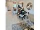 Open-concept dining area and kitchen with a round table, modern bar stools, and bright natural light at 8949 Daybreak St, Sarasota, FL 34241