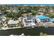 Aerial view of a two-story white house with a canal, dock, and pool located near a beach community at 927 Contento St, Sarasota, FL 34242