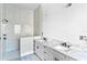 Bathroom with dual sink vanity, granite counters, marble backsplash, and shower with a glass partition at 927 Contento St, Sarasota, FL 34242