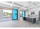 Modern kitchen features a gray island, sleek white cabinets, and sliding glass doors to the outdoor patio at 927 Contento St, Sarasota, FL 34242
