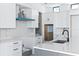 Close up of bright kitchen with gray island, white marble counters, stainless steel appliances, and minimalist black hardware at 927 Contento St, Sarasota, FL 34242