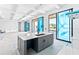 A modern kitchen island in gray with a white countertop, with sliding glass doors to an outdoor patio at 927 Contento St, Sarasota, FL 34242