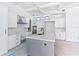 Bright kitchen with gray island, white marble counters, stainless steel appliances, and minimalist black hardware at 927 Contento St, Sarasota, FL 34242