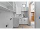 Bright laundry room with open shelves, white cabinets, quartz counters, and a dark sink and faucet at 927 Contento St, Sarasota, FL 34242
