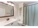 This bathroom has a white sink and cabinet, with shelving next to the toilet and shower at 11744 Shirburn Cir, Parrish, FL 34219