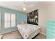 This bedroom features a ceiling fan, blue walls, and a decorative chalkboard art wall at 11744 Shirburn Cir, Parrish, FL 34219