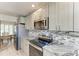 Updated kitchen boasts stainless steel appliances, granite countertops, and decorative backsplash at 11744 Shirburn Cir, Parrish, FL 34219