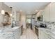 Modern kitchen with granite counters, stainless appliances, and ample cabinet space offers views to dining room at 11744 Shirburn Cir, Parrish, FL 34219