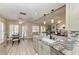Open kitchen with granite counters and stainless-steel appliances offers easy access to the dining area and backyard at 11744 Shirburn Cir, Parrish, FL 34219