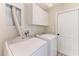 Bright laundry room featuring a washer, dryer, and overhead storage cabinets at 11744 Shirburn Cir, Parrish, FL 34219