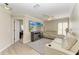 This well-lit living room features two white couches, wood-look floors and a wall-mounted TV at 11744 Shirburn Cir, Parrish, FL 34219