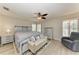 Comfortable main bedroom with a ceiling fan, wood-look floors, and light-colored wood furniture at 11744 Shirburn Cir, Parrish, FL 34219