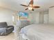 This is a large main bedroom with an ensuite bathroom, gray furniture, a ceiling fan and wood-look floors at 11744 Shirburn Cir, Parrish, FL 34219