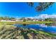 Beautiful pond reflecting the sky, trees and neighborhood homes beyond, providing a scenic backdrop at 11744 Shirburn Cir, Parrish, FL 34219