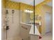 Bright bathroom featuring a walk-in shower, vanity, and cream-colored walls with unique patterned wallpaper at 12019 Sawgrass Lake Ter, Bradenton, FL 34211